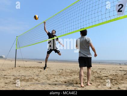 Swansea, South Wales UK, 14 aprile 2018 il sole primaverile ha trovato la costa del Galles sabato come i mesi più caldi sono un gradito ritorno. Gli amici nella foto godendo di una partita di pallavolo in sole di primavera sulla Baia di Swansea. Robert Melen/Alamy Live News. Foto Stock