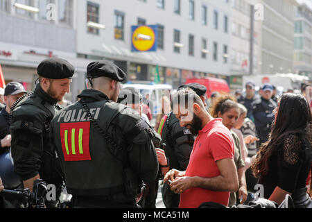 Mannheim, Germania. Il 14 aprile 2018. Un passante da ha la sua identità controllati da funzionari di polizia. Il popolo curdo e i tifosi tedeschi hanno marciato attraverso Mannheim per protestare contro la continua occupazione della città siriana di Afrin, che era controllata dalla popolare curda Unità di Protezione (YPG) prima che hai conquistato dall'esercito turco. Essi inoltre hanno protestato contro la partecipazione tedesca attraverso le esportazioni di armi alla Turchia. Credito: Michael Debets/Alamy Live News Foto Stock