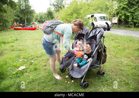 Mamma giovane che spinge un doppio buggy in vacanza con i gemelli. Foto Stock