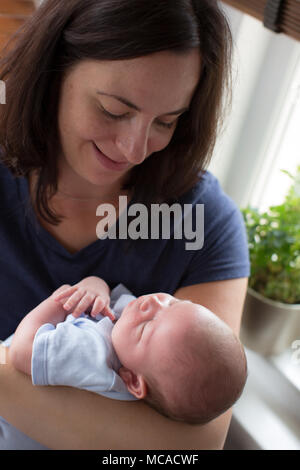 Una mamma più anziana che tiene il suo figlio neonato. Foto Stock