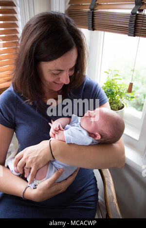 Una mamma più anziana che tiene il suo figlio neonato. Foto Stock