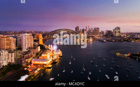 Dark tramonto sul Sydney landmarks intorno a Sydney Harbour su entrambi i lati del ponte del Porto di Sydney in vista aerea sulle acque della baia di Lavanda con flottazione Foto Stock