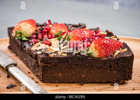 Fetta di sano brownie con fragola e melograno seme. Foto Stock