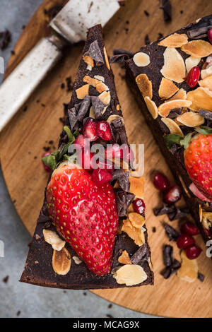 Brownie con batata,fragola e melograno. Foto Stock