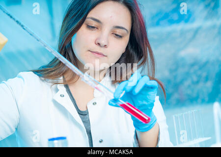 Gli scienziati la miscelazione di prodotti chimici. Esperimento di chimica Foto Stock