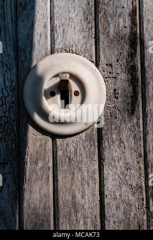 Vecchia luce elettrica switch su una parete in legno Foto Stock