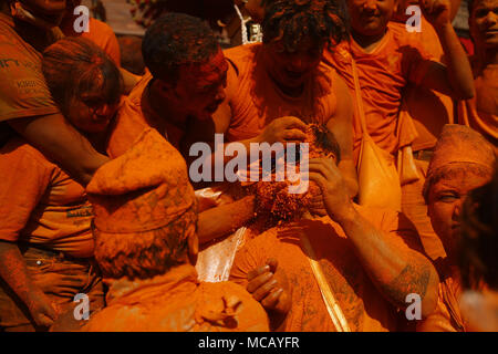 Bhaktapur, Nepal. Xv Apr, 2018. Vermiglio polvere colorata è cosparsa di un uomo durante il festival Sindoor a Thimi in Bhaktapur, Nepal Domenica, 15 aprile 2018. I festaioli portato carri di divinità Indù e dee e scaraventato vermillion polvere su ogni altro come parte delle celebrazioni a partire nepalesi per Nuovo Anno soprattutto dall'etnia Newar comunità. Credito: Skanda Gautam/ZUMA filo/Alamy Live News Foto Stock