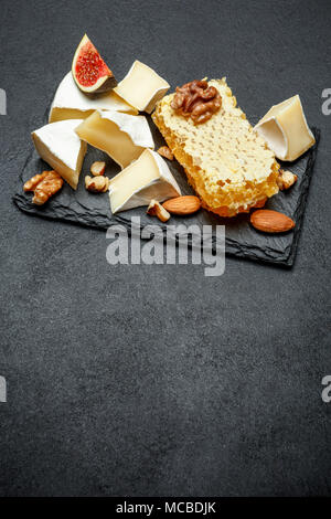 Formaggio Camembert con miele, fichi, noci sul bordo di pietra Foto Stock