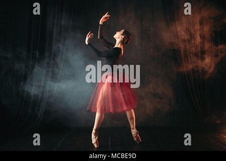 Ballerina in abito rosso ballando sul palco Foto Stock