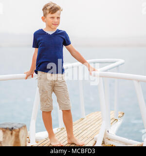 Piccolo Ragazzo godendo le vacanze estive sul mare. Felice ragazzo su yacht crociera. Immagine con spazio di copia Foto Stock