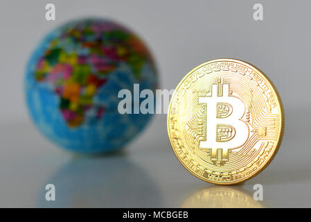 Bitcoin concetto. Economia mondiale concetto. Nuova moneta mondiale. Medaglia d'oro bitcoin e globo. Foto Stock