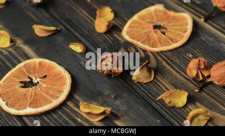 Fette di arancia e ibisco Petali su sfondo di legno. Foto Stock