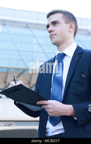 Imprenditore firma di accettazione contratto report, moderno ed alto in background. Foto Stock