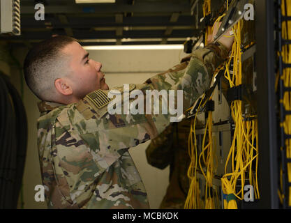 Il personale Sgt. Brandon Hasegawa, 455th comunicazione Expeditionary Squadron cyber tecnico di trasporto, controlla il non-secure internet protocol Router fili Mar. 22, 2018 a Bagram Airfield, Afghanistan. Hasegawa è caricato con il mantenimento e la gestione della base non-secure internet protocol router, secret internet protocol Router e il completo Airman rete Fitness. Foto Stock