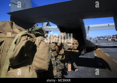 Marines con 1° aria Naval spari Liaison Company, xiii Marine Expeditionary Unit, imbarcatevi su una MV-22 Osprey a bordo Wasp-classe nave anfibio USS Essex (LHD 2), 26 marzo 2018. L'Essex anfibio gruppo pronto e il XIII MEU completamente integrate per la prima volta prima della loro implementazione in estate. Squadrone anfibio, MEU integrazione la formazione è un elemento cruciale di pre-distribuzione esercizio che consente al corpo di Navy-Marine team rapidamente a pianificare ed eseguire complesse operazioni di spedizione navale. Foto Stock