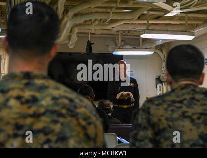 Oceano Pacifico (29 marzo 2018) Lt. David Tambur, Cappellano Corps, da El Paso, Texas, assegnato a San Antonio-classe di trasporto anfibio dock USS ancoraggio (23 LPD), legge una scrittura dalla Bibbia durante il Giovedì Santo la cerimonia di culto nella cappella. Ancoraggio è attualmente in corso con il XIII Marine Expeditionary Unit (MEU) per un squadrone anfibio e MEU integrazione (PMINT) esercizio. PMINT è una evoluzione di formazione fra Essex anfibio gruppo pronto e il XIII MEU, che consente i marinai e Marines di treno come un'unità coesiva in preparazione per la loro prossima distribuzione. Foto Stock