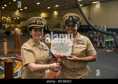 NORFOLK, Virginia (Mar. 30, 2018) -- Chief Navy Consigliere Roynika amore, assegnato alla USS Gerald Ford (CVN 78) dipartimento amministrazione, riceve un certificato di onorevoli scarica dalla Ensign Kristine Gavino, Ford personale del funzionario, durante la sua cerimonia reenlistment in nave hangar. Foto Stock