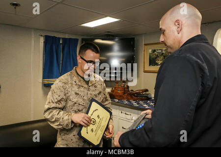 Stati Uniti 5TH FLOTTA AREA DI OPERAZIONI (31 marzo 2018) Marine Corps Lance Cpl. Evan O'Reilly, sinistra, 20, nativo di Gardner, Massachusetts e il membro del team assegnato alla società di Fox, battaglione atterraggio squadra, 2° Battaglione, 6° Reggimento Marini, 26 Marine Expeditionary Unit, riceve il marino in Spotlight award dalla Cmdr. Philip Knight, destra, comandante della harpers Ferry-class dock landing ship USS Oak Hill (LSD 51) a bordo di una nave. L'Oak Hill è distribuito negli Stati Uniti Quinta Flotta area di operazioni a sostegno della sicurezza marittima operazioni per rassicurare gli alleati e partner e preservare il Foto Stock