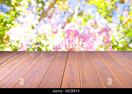 Pianale di legno con sfocato fiori colorati della natura, parco giardino in estate sfondo , concetto è per montaggio display del prodotto,chiave di progettazione layout visivo Foto Stock