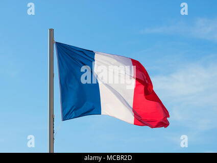 Bandiera francese che fluttua in un vivace brezza contro un luminoso cielo blu in estate sfondo. Foto Stock