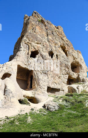 Cappadocia: antiche abitazioni di roccia scolpita nella naturale di formazioni di roccia vulcanica nel paesaggio della Cappadocia a Goreme Foto Stock