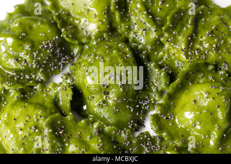 Vista dall'alto ingrandimento di una piastra di verde riempito la pasta italiana, Ravioli di spinaci con olio e semi di papavero Foto Stock