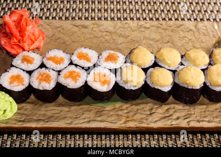Due tipi di sushi tradizionale Giapponese rotoli futomaki su una rettangolare piastra stilizzata closeup Foto Stock