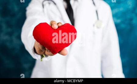 Medico tenendo un cuore rosso toy close up Foto Stock