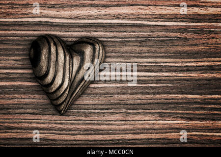 Strisce di legno cuore collocato su un vintage grunge Sfondo legno. Foto Stock