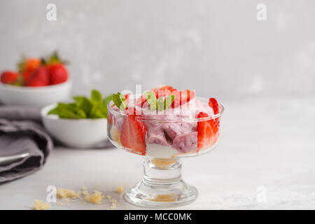 Dolce alle fragole. Berry inezia, cheesecake, parfait. Berry mousse in vetro su uno sfondo luminoso. Foto Stock