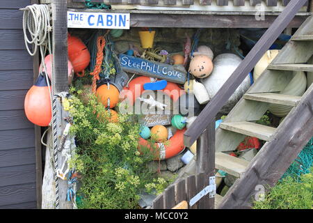 Collezione di coloratissimi flotsam e jetsam appeso su una cabina di legno in Steephill Cove, Ventnor, Isle of Wight, England, Regno Unito, Peter Grant Foto Stock