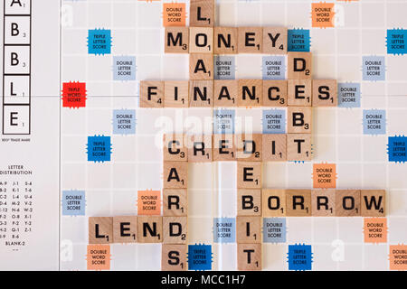 Una serie di parole su una scheda di scrabble relativi alle finanze e debito Foto Stock