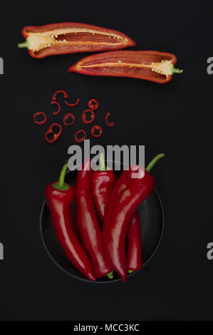 Fresco di pepe rosso su nero tabella Foto Stock