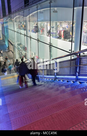 Scena notturna con pedoni su una scala nei pressi di un centro commerciale in una zona commerciale a Pechino, Cina Foto Stock