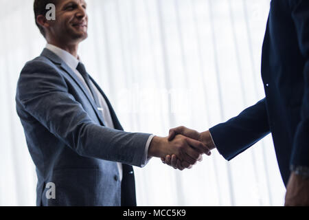 Business Partner si stringono la mano e la finitura di una riunione. Sorridente imprenditrice stringono le mani con un collega. Foto Stock