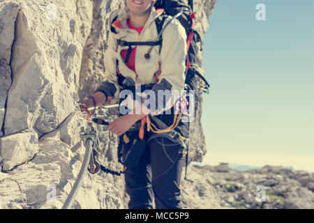 Primo piano dello scalatore femmina attacco di set da via ferrata. Foto Stock