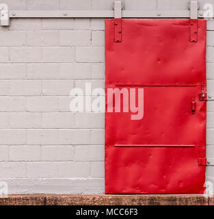 Vecchio rosso scorrevole porta dock su rulli e rampa. Foto Stock
