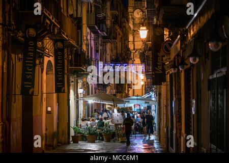 La gente seduta fuori a mangiare in una pizzeria a Palermo, Sicilia, Italia, durante la notte in estate. Foto Stock