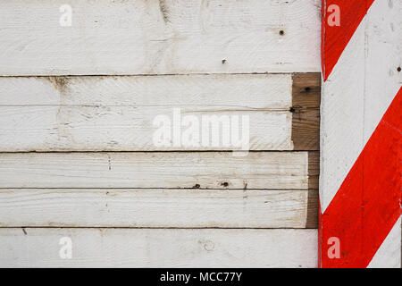 Rosso e bianco barriere in legno posto lungo la costruzione della parete del sito . Foto Stock