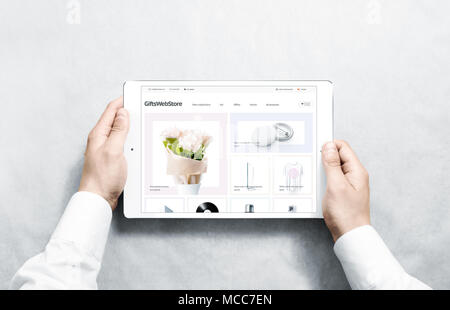 Mani di tablet con doni webstore mock up sullo schermo, isolata. Abbigliamento pagina web interface mockup. Il sito internet di modello online sul devi Foto Stock