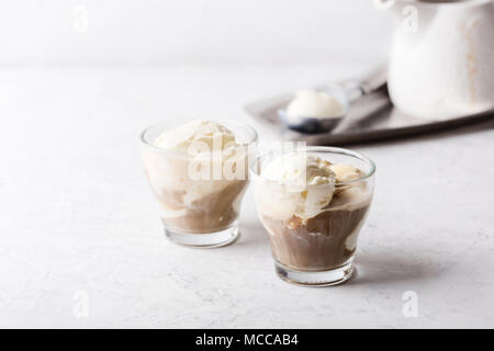 Affogato in casa, tradizionale dolce italiano con gelato alla vaniglia e caffè espresso su di colore grigio chiaro nella tabella Foto Stock