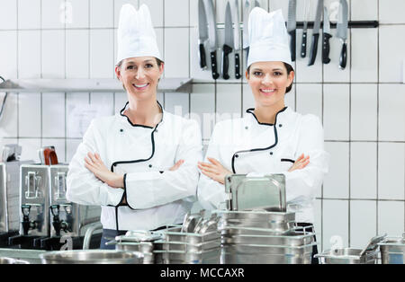 Chef indossando abiti da lavoro in cucina industriale Foto Stock