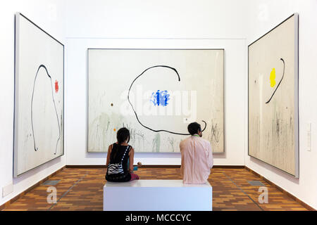 Due persone all interno di un museo guardando dipinti alla Fondazione Joan Miró di Barcellona, Spagna '(la speranza di un condannato' serie da Miro) Foto Stock