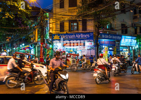 Occupato il traffico in moto di notte nel quartiere vecchio di Hanoi. Negli ultimi decenni le motociclette hanno superato le biciclette come la principale forma di trasporto Foto Stock