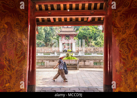 Donna vietnamita indossando il tradizionale hat camminando nel terzo cortile del Tempio della Letteratura (vietnamita: Văn Miếu) un Tempio di Confucio in Hanoi Foto Stock