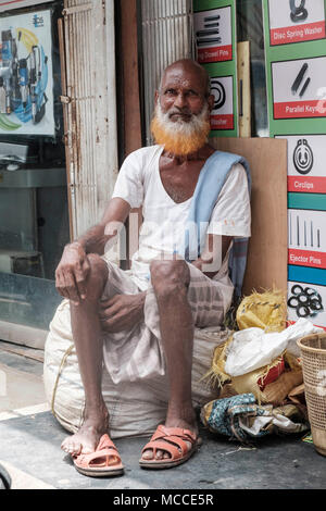 Uomo vecchio con un henné tinti in barba al di fuori di un negozio sulla strada Nagdevi vicino mercato Crawford in Mumbai Foto Stock