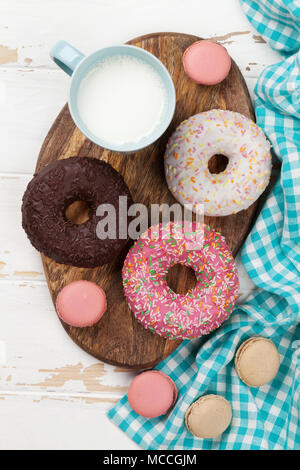 Latte, amaretti e ciambelle su un tavolo di legno. Vista superiore Foto Stock