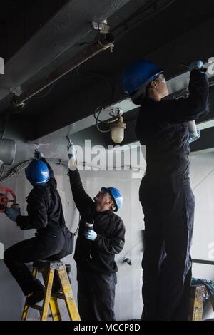 180208-N-WZ681-111 Yokosuka, Giappone (feb. 8, 2018) marinai dipingere un angolo-ferro da stiro su un ponte scoperto a bordo della marina distribuita portaerei USS Ronald Reagan (CVN 76), durante la nave selezionato disponibilità limitata. Ronald Reagan, il portabandiera del Carrier Strike gruppo 5, fornisce un combattimento-pronto forza che protegge e difende la collettiva degli interessi marittimi dei suoi alleati e partner in Indo-Asia-regione del Pacifico. (U.S. Foto di Marina di Massa Specialista comunicazione marinaio Randy Lee Adams II/rilasciato) Foto Stock