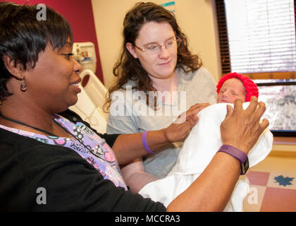 Theresa Perry, licenza infermiera professionale, Unità Postpartum, William Beaumont Army Medical Center, aiuta Kayla Simons, prime-time MOM e Fort Bliss coniuge militare, regolare il neonato Hunter Simons' coperta come egli indossa un po' di Red Hat, parte di una iniziativa nazionale volto a dotare le mamme di cuore vivo di vita salutare e incoraggiare i bambini a fare lo stesso in onore di cardiopatia congenita la settimana di consapevolezza (feb. 7-14), a WBAMC, Feb. 7. Foto Stock