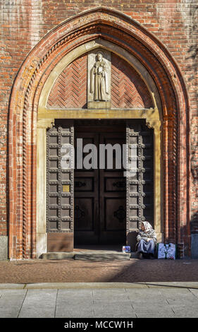 Milano, Italia - 1 Aprile 2018: Una donna anziana mendicante che sembra essere una Roma Gypsie elemosina davanti a una chiesa a Milano Foto Stock